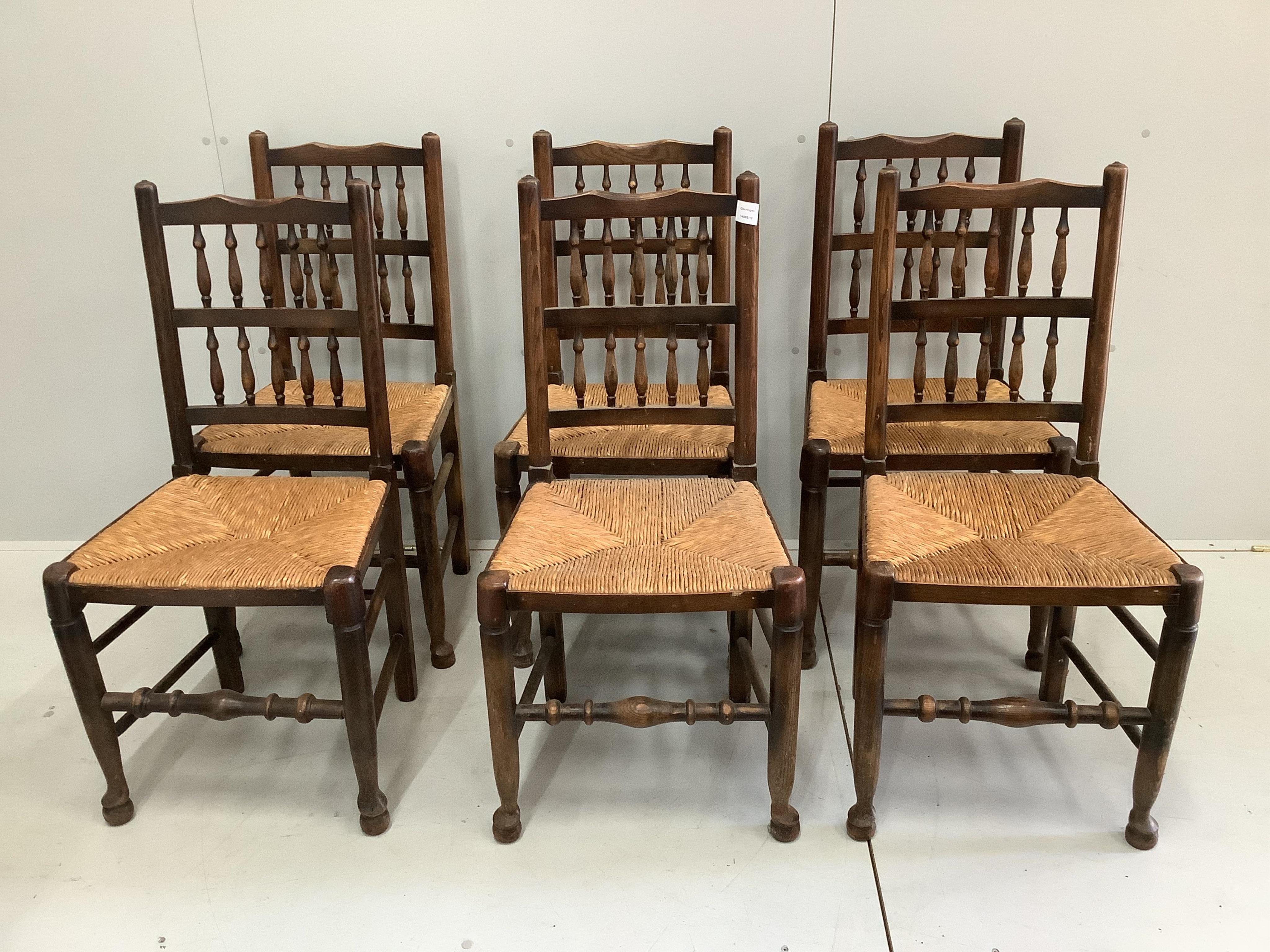 A set of six Lancashire ash and beech rush seated spindle back dining chairs, width 46cm, depth 38cm, height 92cm. Condition - fair